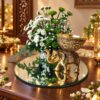 Elephant candle holder centrepiece with white Calimero and green button chrysanthemums on a mirror base, angled view