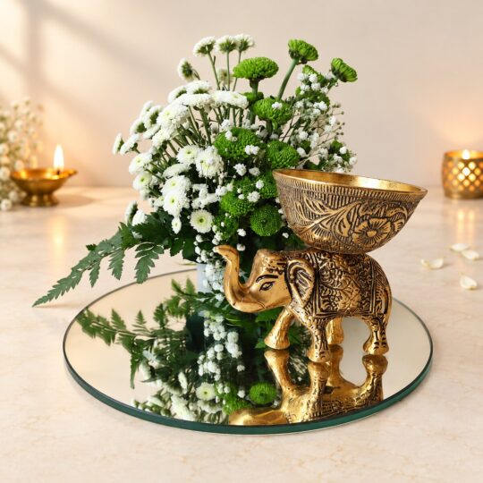 Diwali elephant centrepiece in Bangalore with an antique gold metal elephant candle holder, white and green chrysanthemums and a round mirror base