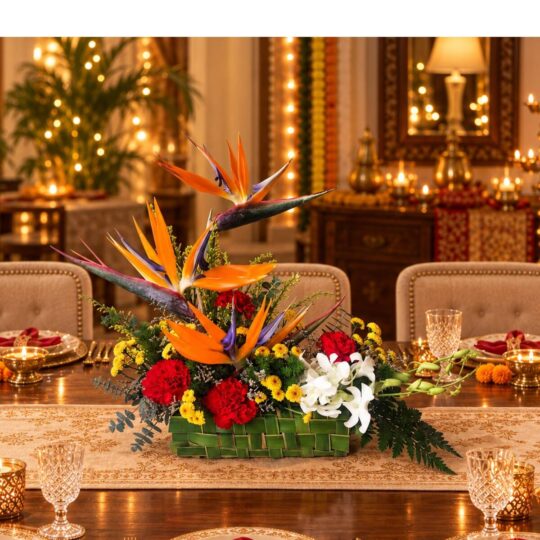 Bird of paradise and orchid centrepiece in a woven leaf base, front view