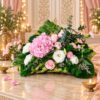 Pastel pink hydrangea, rose and carnation arrangement on a woven coconut leaf base, front view