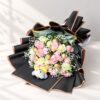 Rose and carnation bouquet with Ferrero Rocher and plush teddy lying flat, angled view