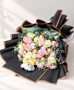 Rose and carnation bouquet with Ferrero Rocher and plush teddy lying flat, angled view