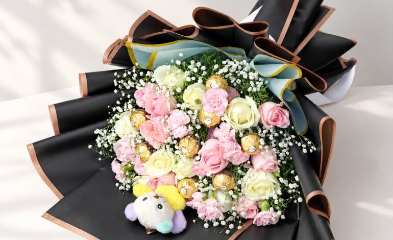 Rose and carnation bouquet with Ferrero Rocher and plush teddy lying flat, angled view