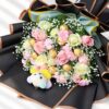 Pink and white roses with spray carnations and Ferrero Rocher in a black wrapped bouquet, top close-up