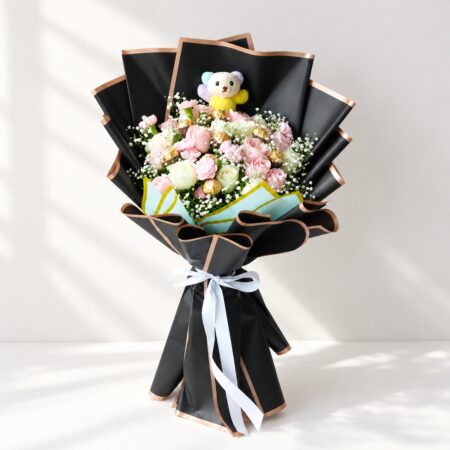 Rose bouquet with chocolates in Bangalore with pink and white roses, pink spray carnations, Ferrero Rocher and a mini teddy in black wrap