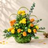 Diwali marigold table arrangement in Bangalore with yellow and orange marigolds, eucalyptus and ferns in a woven coconut leaf basket