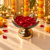 Decorative glass urli bowl in Bangalore in amber lotus glass on a gold metal stand filled with red rose petals