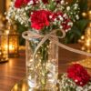 Glass jar with red carnations, baby's breath, fairy lights and a jute twine bow, close-up
