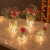 Glowing glass jars with pink-edged roses and baby's breath, top angle view