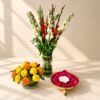 Diwali urli decoration in Bangalore with a tuberose and gladiolus vase, a marigold matki vase and a metal urli of red rose petals with candle
