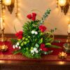 Red rose and white carnation arrangement with ferns and eucalyptus in a woven leaf basket, top angle view