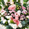 Close-up of pink roses, lisianthus, white spray carnations and pink santini chrysanthemums with eucalyptus