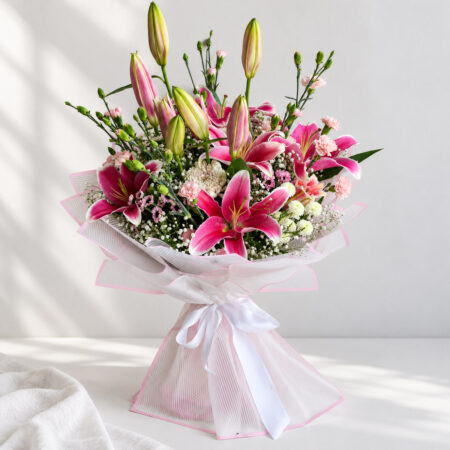 Fragrant pink lily bouquet in Bangalore with oriental lilies, spray carnations, chrysanthemums and baby's breath in white and pink wrap
