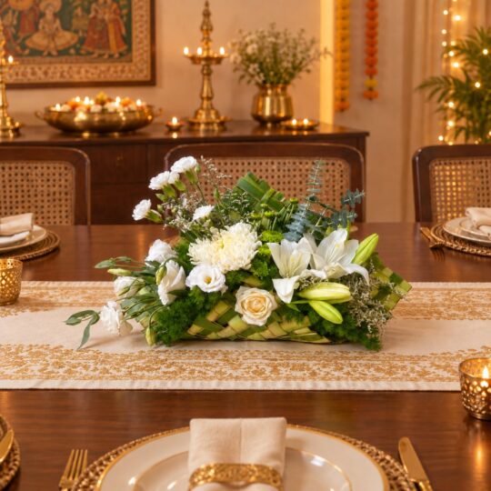 White lily and eustoma centrepiece in a woven leaf base on a dining table, front view