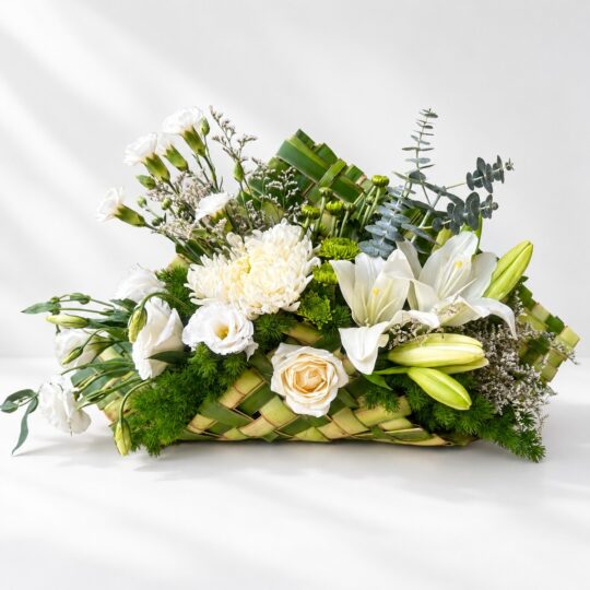 White flower arrangement in Bangalore with fragrant oriental lilies, eustoma and chrysanthemum in a woven coconut leaf base