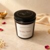 Scented candle in amber glass jar with gold Light & Love lid print, angled view