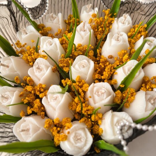 White tulip shaped candles with dried mustard baby's breath, close-up