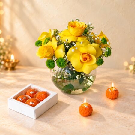 Yellow rose and button chrysanthemum vase with laddoo candles lit, angled view
