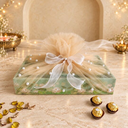 Mint lotus-print dry fruits hamper wrapped in champagne tulle with pearl beads and a white organza bow