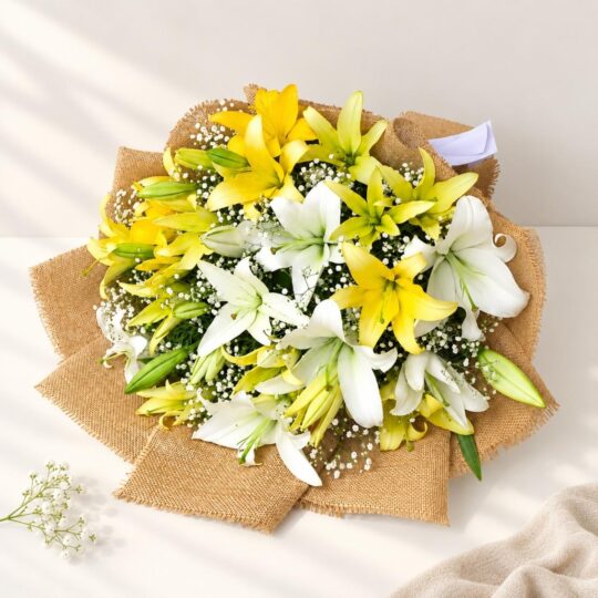 Yellow and white lilies with baby's breath in a jute wrap, seen from above on a white table