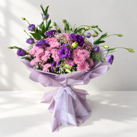Purple lisianthus bouquet in Bangalore with pink chrysanthemums and baby's breath in lilac wrap