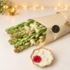 Fragrant white tuberose bunch in kraft paper with a scented gold metal urli candle, close-up view