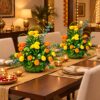 Two marigold centrepieces in woven leaf baskets on a Diwali dining table, shown for scale, wide view