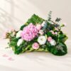 Pink hydrangea centrepiece in Bangalore with pink roses, spray carnations, white eustoma and eucalyptus on a handwoven coconut leaf base