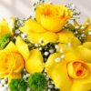 Yellow roses with green button chrysanthemums and baby's breath, close-up