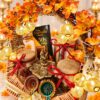 Panch diya, clay diyas and dry fruit jars in a cane Diwali hamper with gold fairy lights, close front view