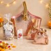 Rose gold gift bag with potpourri, wax sachet and drawstring dry fruit potlis, angled view