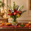 Tuberose and red rose vase arrangement with golden rod on a console, front view