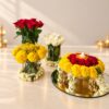 Diwali flower decoration set in Bangalore with red rose, white rose and marigold vases, mogra collars and an elephant urli on a mirror